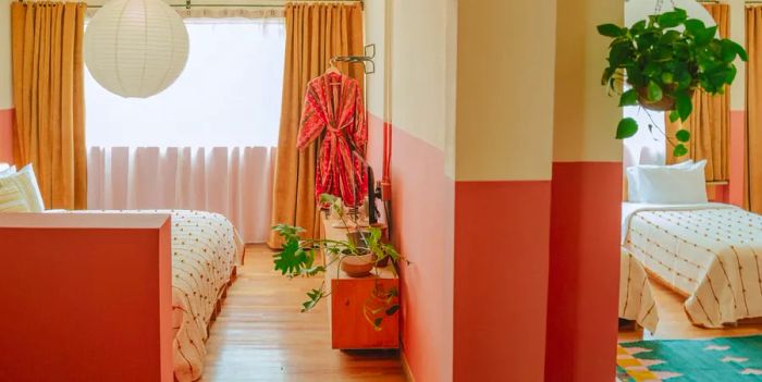 The Ocio Suite at Hotel San Fernando in Mexico City showcases warm tones of pink, peach, and turquoise.