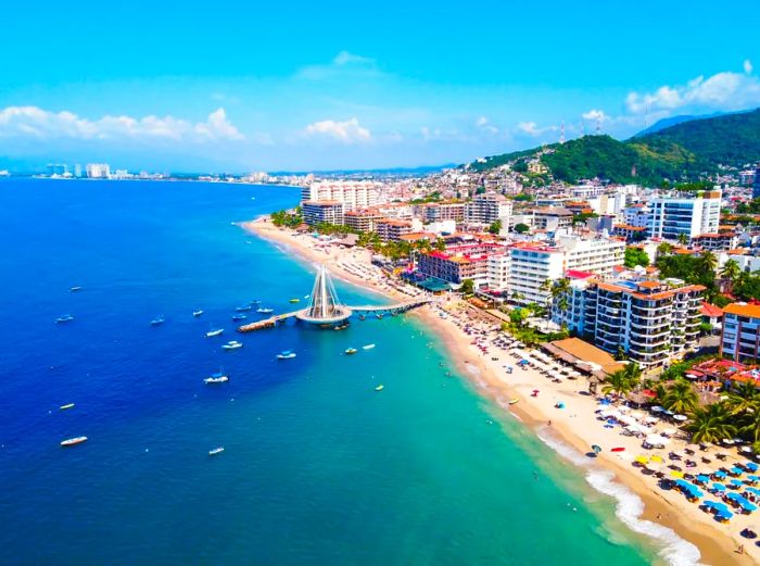 Aerial view of shimmering turquoise waters beside a beach dotted with tall hotels