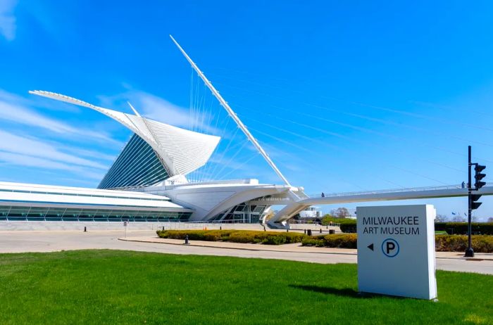 A striking modernist structure behind a sign that reads 'Milwaukee Art Museum.'