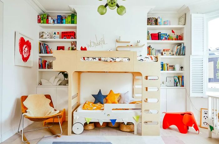 A children’s play area featuring a contemporary bunk bed, toy-filled shelves, a sleek leather chair, and a small red elephant-shaped seat.