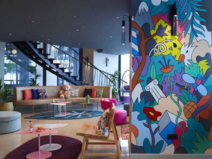 The vibrant lobby of Moxy Athens City, featuring bold murals and sleek modern furnishings