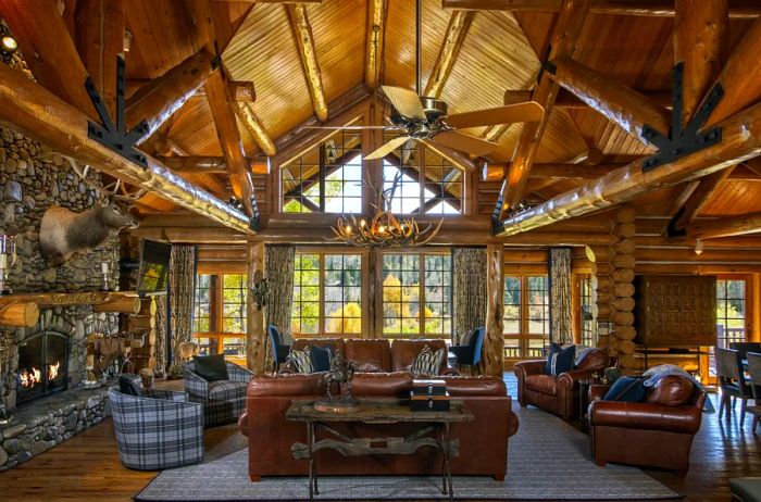 A lavish cabin featuring leather sofas and a mounted elk head.