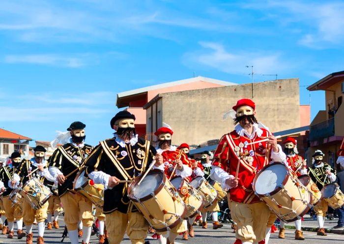 Drummers march vibrantly down the street.