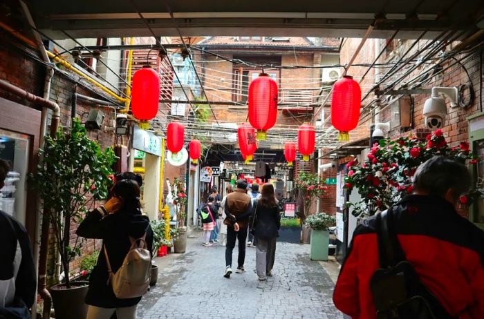 Red lanterns adorn the narrow streets as shoppers stroll through The Tianzifang District in China.