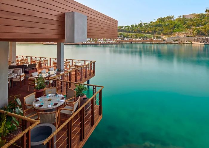 Spago restaurant at Maxx Royal Bodrum features outdoor seating that appears to hover over the water.