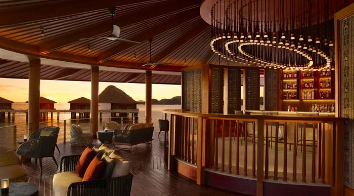 A circular roofed deck adorned with chairs and an open-air bar, bathed in twilight hues.