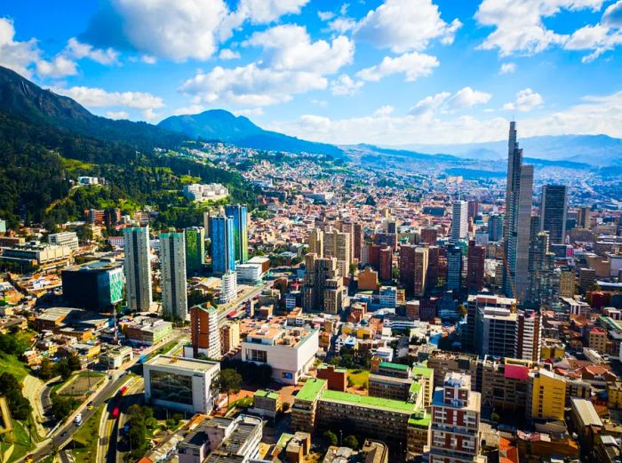 An aerial view of towering buildings embraced by the mountains in Bogotá, Colombia.