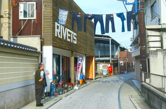 Rivets denim shop in Kurashiki, Japan, featuring a clothesline of jeans across a narrow street