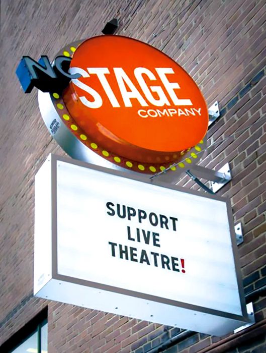 A photo showcasing the exterior signage of the NC Stage Company in Asheville.