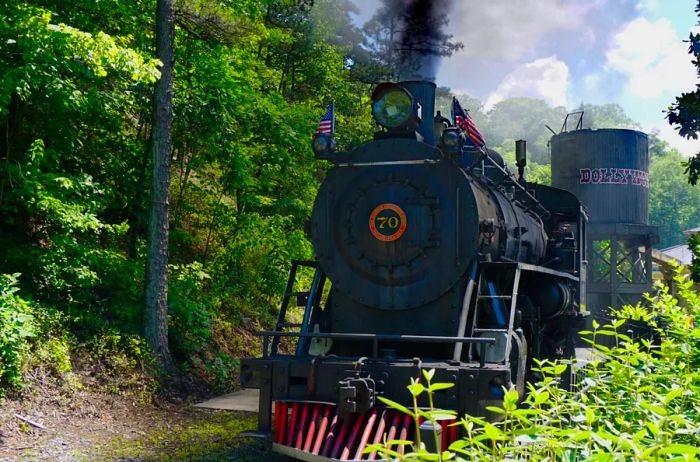 A black train engine navigating through the forest at Dollywood