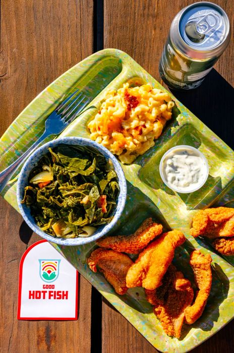 An image of a cafeteria-style tray filled with delicious food from Good Hot Fish, set on a picnic table in Asheville.