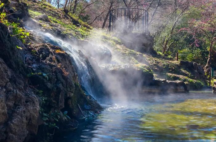 A stream cascades over a rock during the day.