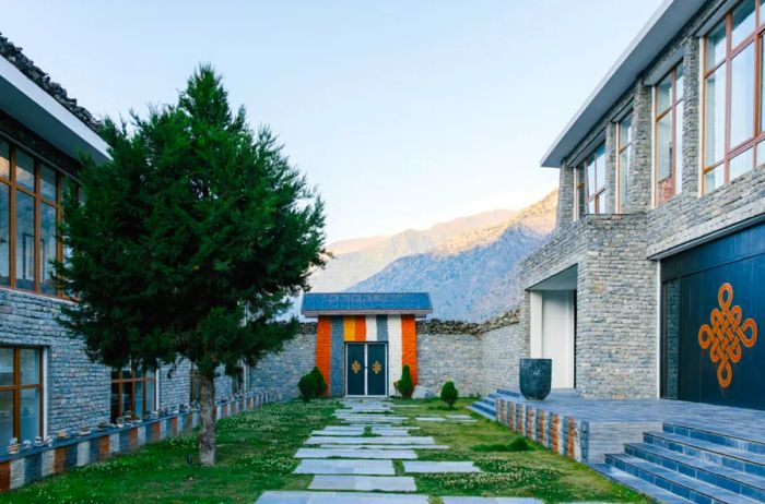 The interior courtyard boasts a stone pathway and a door adorned with a Tibetan knot symbol, which represents the Buddha's boundless wisdom and compassion.