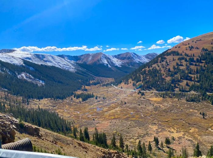 Scenic viewpoint on a Colorado road, overlooking valley and forested mountains