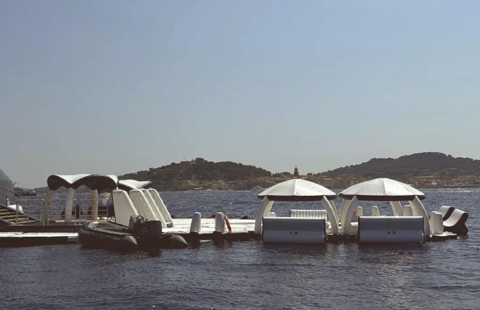 An arrangement of white inflatable cabanas, decks, and chairs creates a temporary pool area off the marina of the 