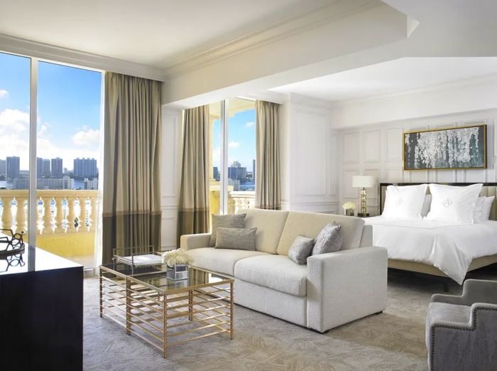 A bright white Deluxe Intracoastal room at Acqualina Resort, offering stunning views of the city skyline.