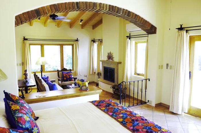 The bedrooms at Rancho La Puerta showcase a predominantly white aesthetic, accented with colorful pillows and throws.