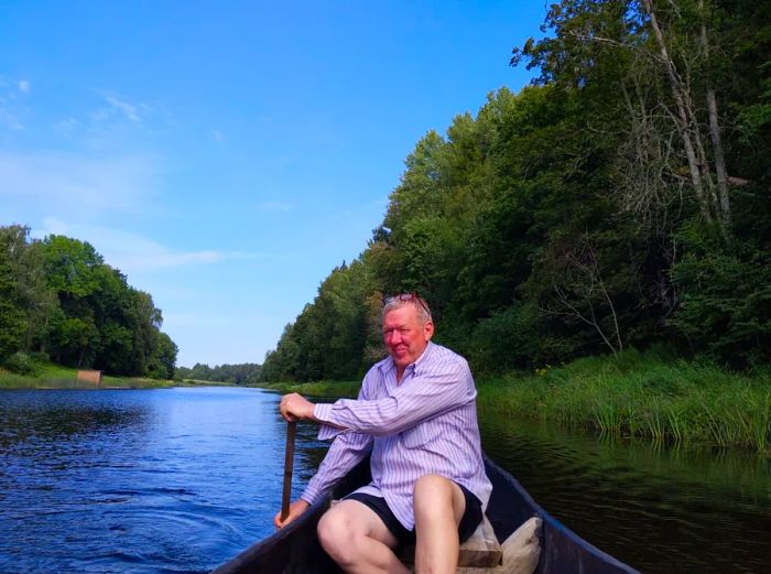 Estonian man paddling a traditional wooden dugout canoe in Soomaa National Park