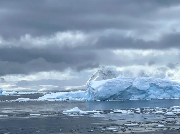 Overcast skies loom above an iceberg in Antarctica.