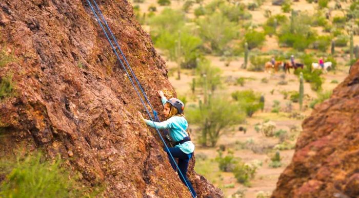 A young girl climbing a mountain at White Stallion Ranch in Tucson, Arizona.