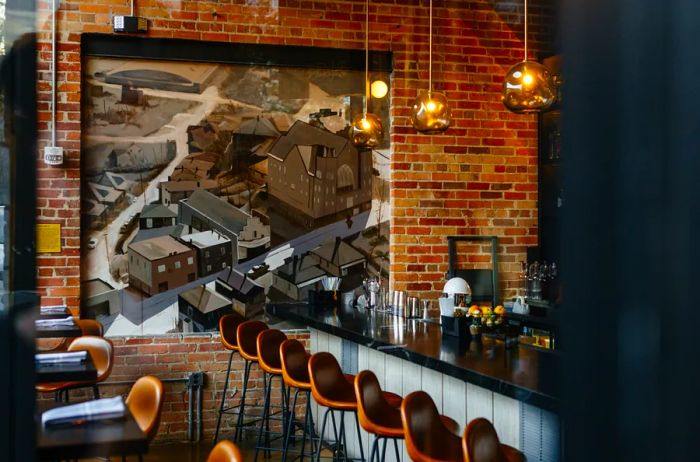 High-backed leather bar stools lined up at the bar of Benne on Eagle restaurant