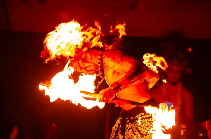 A performer captivating the audience with flaming sticks during a show by Polynesian Fire Productions in Myrtle Beach, South Carolina.