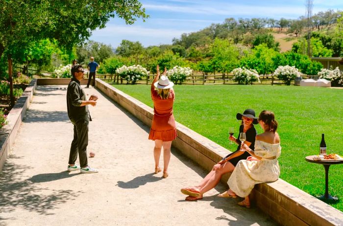 A group of people enjoying a bocce game on the green lawn at the winery