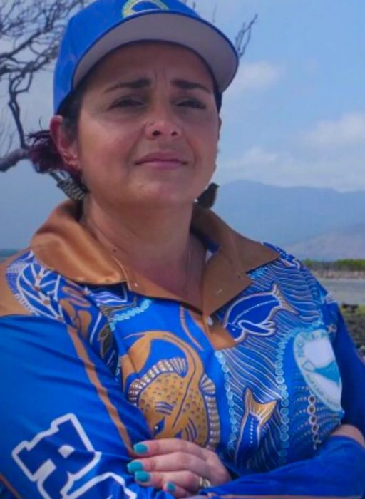 Larissa Hale, the founder of the Queensland Indigenous Women Rangers Network, is seen wearing a blue and gold Rangers jacket and cap in an outdoor setting.