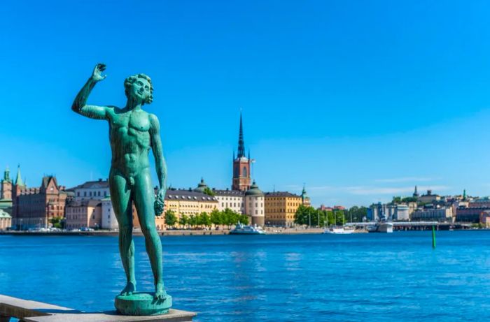 A green statue of a naked man stands majestically by the waters of Stockholm Harbor, Sweden.