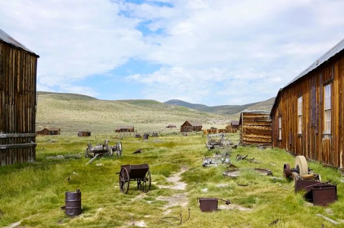 Brown houses scattered across lush green plains and hills.