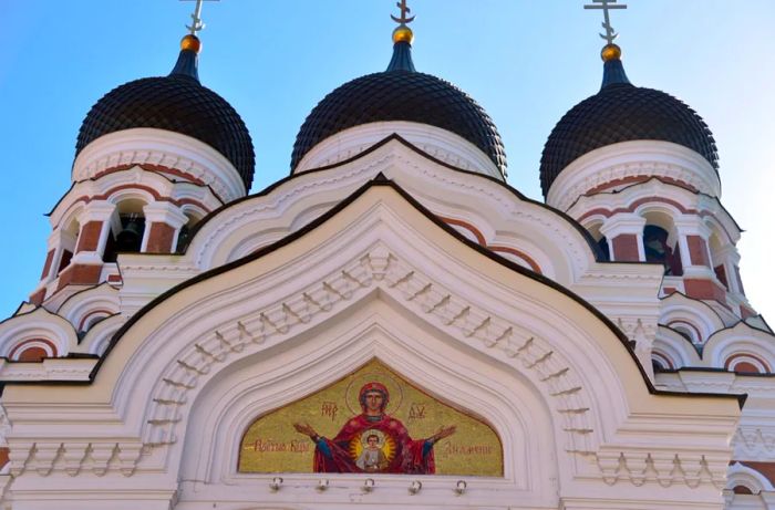 The Alexander Nevsky Cathedral in Estonia features tall, rounded white spires adorned with a depiction of Jesus.