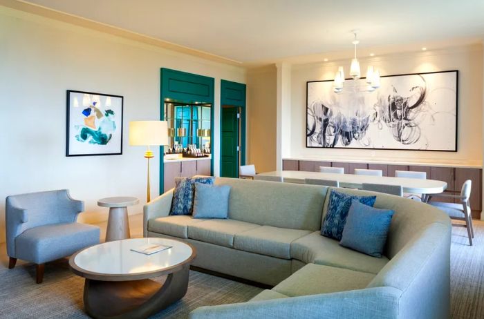 The living area of the Orchid Presidential Suite at the JW Marriott Miami Turnberry Resort & Spa features abstract artwork and a spacious couch.