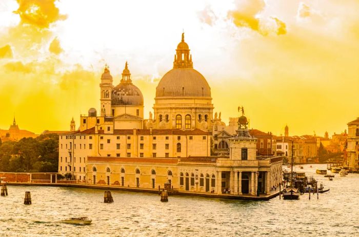 A domed structure extending over the water, framed by a yellow, cloudy sky in Venice.