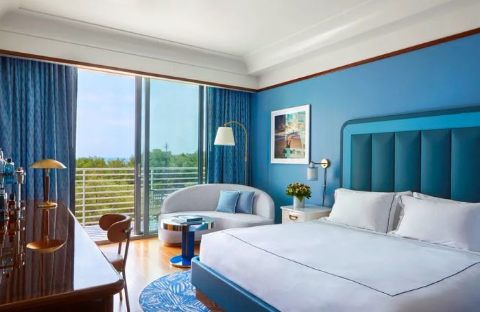 A King room at the Mr. C Miami hotel, featuring a blue and white color scheme and a balcony.