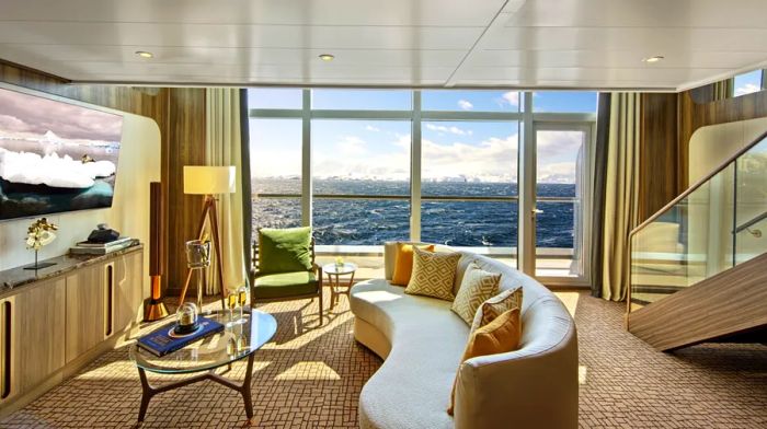 The two-story Grand Wintergarden suite aboard the 'Seabourn Venture' features a sofa and chairs on the lower level, with a loft above.