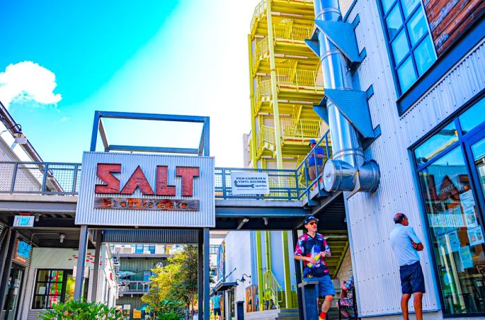 A view of the SALT signage and vibrant yellow stairs at Our Kakaako, which features an array of restaurants and retail shops.