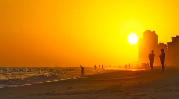 Sunset on Orange Beach Alabama with people in hazy fog