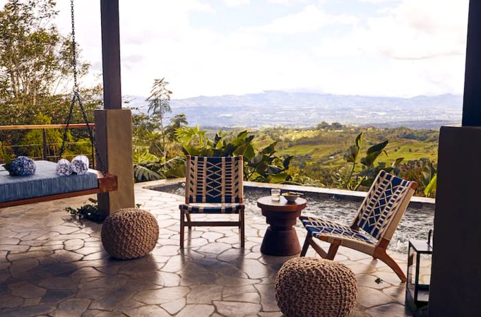 Stone patio featuring empty chairs and a hanging seat at Hacienda AltaGracia