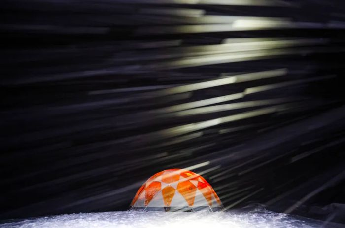 At night on the Greenland ice cap, a mess tent stands illuminated.