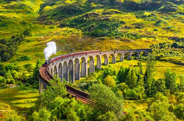 Glenfinnan Railway Viaduct in Scotland with the Jacobite steam train crossing over