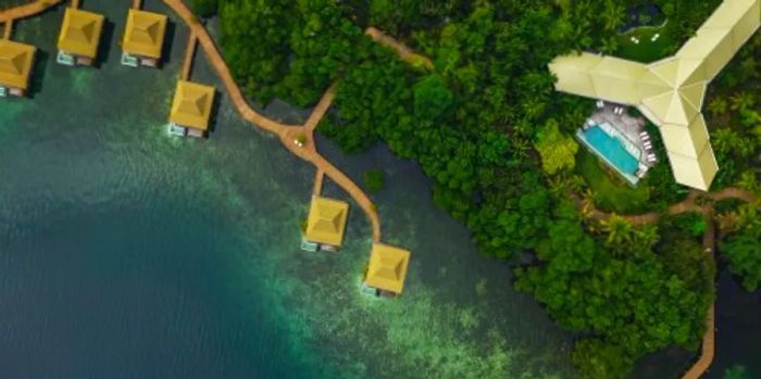 Aerial view of the overwater villas, mangrove island, and ocean at Nayara Bocas del Toro, Panama