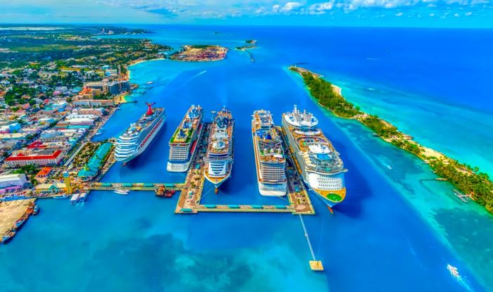 Aerial view of five large cruise ships docked in the Bahamas.