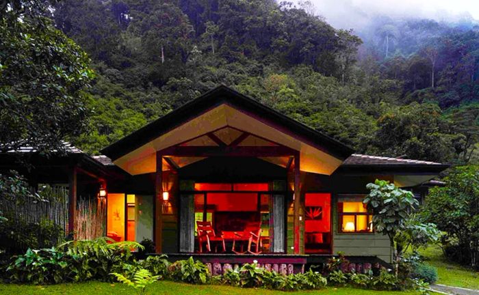 The exterior of a villa at El Silencio Lodge & Spa, featuring a deck illuminated from within.