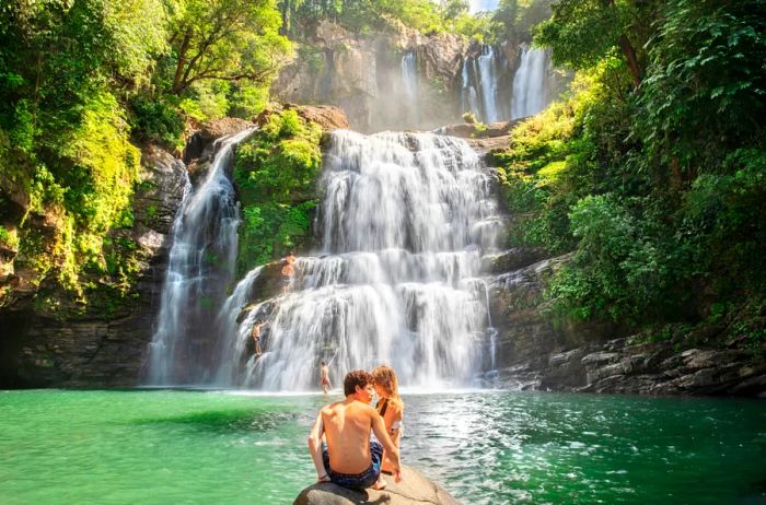 Two visitors enjoying a waterfall at Manuel Antonio National Park