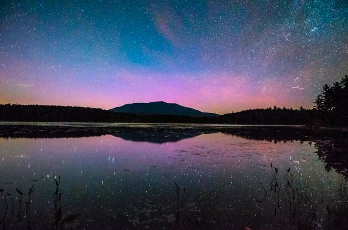 A magenta-tinted sky over a lake in Maine