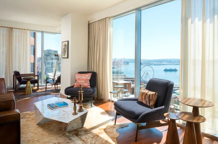 A suite at the Thompson Hotel in Seattle features expansive floor-to-ceiling windows offering stunning views of the city’s waterfront.