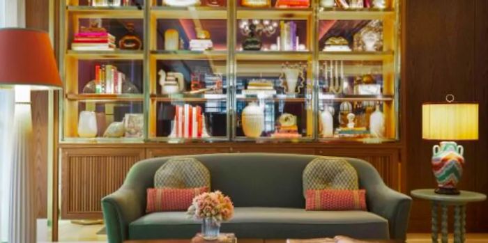 The lobby features plush velvet sofas and well-stocked bookshelves.