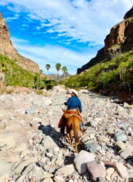 A rider on horseback traversing the rocky terrain of Sierra de San Francisco.