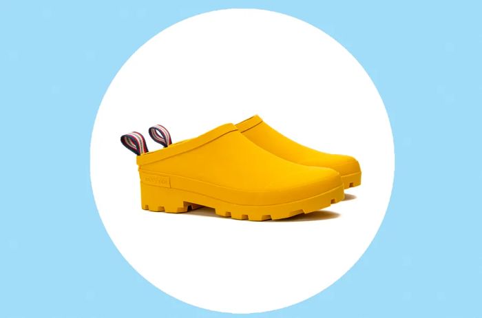 Yellow SeaVees Bodega Clogs on white circle on soft blue backdrop