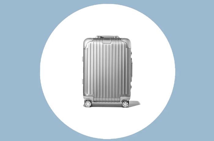 Rimowa Original Cabin Carry-On in Silver displayed on a white circle against a gray background